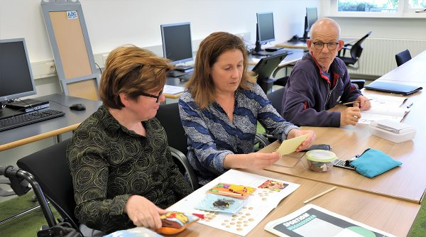 drie personen in overleg over laaggeletterdheid