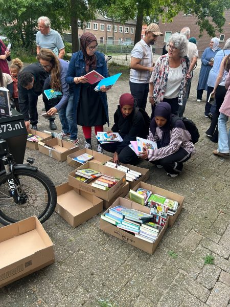 Bezoekers zoeken boeken bij de Boekenbakfiets
